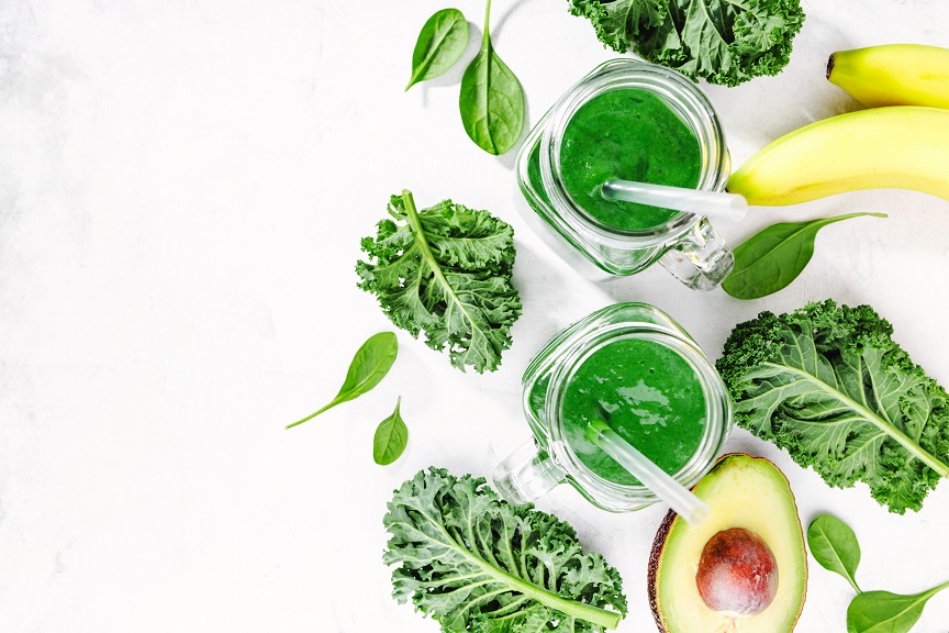 Fresh made healthy green smoothie served in jars on bright table. Fruits and vegetables ingredients around. Closeup with Copy space. Horizontal.